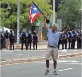  ?? THAIS LLORCA, EUROPEAN PRESSPHOTO AGENCY ?? People face off with police during a strike against austerity measures, in San Juan, Puerto Rico, on Monday.