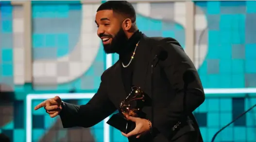  ?? PHOTOS: MIKE BLAKE/REUTERS ?? Canadian rapper Drake accepts his Grammy for best rap song for God’s Plan. The hitmaker was supposed to be absent from Sunday’s event in Los Angeles.