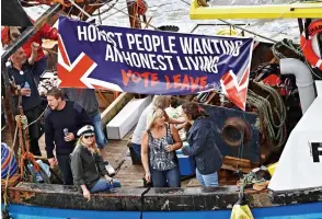 ??  ?? Ailing industry: This boat appeals to voters to save fishermen’s way of life Party boat: Brexit backers enjoy drinks as they cruise down the Thames