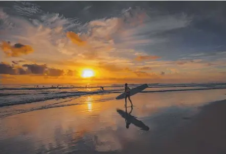  ?? Picture: JULES INGALL ?? Heading for the waves on a golden Gold Coast morning.