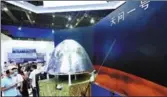  ?? LONG WEI / FOR CHINA DAILY ?? Visitors examine a model of the landing capsule Tianwen 1 in Shanghai in September.