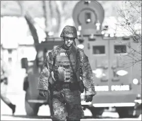  ?? Lansing State Journal via AP/MATTHEW DAE SMITH ?? Law enforcemen­t officers search a wooded area for a suspect involved in a shooting at a Central Michigan University residence hall on Friday in Mt. Pleasant, Mich.