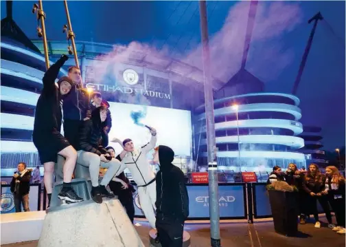  ?? Associated Press ?? ↑
Manchester City fans celebrate outside the Etihad Stadium in Manchester on Tuesday.