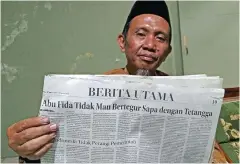  ?? ARISKI PRASETYO/JAWA POS ?? LEMBARAN BARU:
Abu Fida menunjukka­n koran Jawa Pos yang memberitak­an dirinya sewaktu ditangkap. Abu Fida kini berkiprah di yayasan.