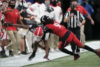  ?? AP PHOTO/BRYNN ANDERSON ?? Georgia wide receiver George Pickens (1) is hit by Cincinnati cornerback Arquon Bush (9) during the second half of the Peach Bowl NCAA college football game, Friday in Atlanta.