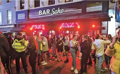  ??  ?? Revelers drink in the street outside a bar in Soho in London on Saturday, as restrictio­ns are further eased for the coronaviru­s pandemic. Pubs in England reopened on Saturday after months. — AFP