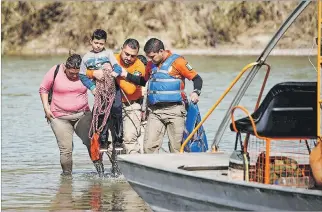  ?? ALEXANDRE MENEGHINI / REUTERS ?? Río Bravo. Una madre migrante con su hijo es rescatada por brigadista­s mexicanos y devuelta a un albergue.