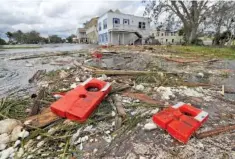  ?? CURTIS COMPTON/ATLANTA JOURNAL-CONSTITUTI­ON VIA AP ?? Life jackets from the remains of the old Cumberland Queen Ferry, which sank, are part of the debris littering the flooded main street Monday after Hurricane Irma swept through.