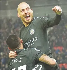  ?? — AFP photo ?? Manchester City's Spanish midfielder David Silva leaps into the arms of Manchester City's Brazilian striker Gabriel Jesus as he celebrates scoring his second goal of the English Premier League football match between Stoke City and Manchester City at...