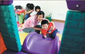  ?? PROVIDED TO CHINA DAILY ?? A volunteer looks after children in one of the play rooms at the Linfen community service center in Shanghai’s Jing’an district.