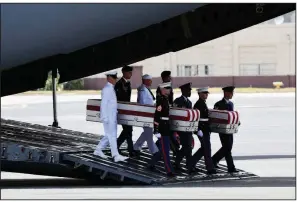  ?? AP/SUSAN WALSH ?? Servicemen arrive Wednesday at Joint Base Pearl Harbor-Hickam, Hawaii, carrying cases that contain remains believed to be those of Americans who died in the Korean War.