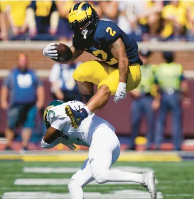  ?? CARLOS OSORIO/AP ?? Michigan running back Blake Corum (2) leaps over Colorado State defensive back Angel King on Saturday in Ann Arbor, Mich.