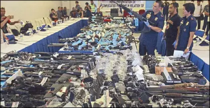  ?? JOVEN CAGANDE ?? Chief Superinten­dent Guillermo Eleazar inspects guns and ammunition recovered in Calabarzon from April 21 to May 6 with the implementa­tion of the election gun ban, at Camp Vicente Lim yesterday.