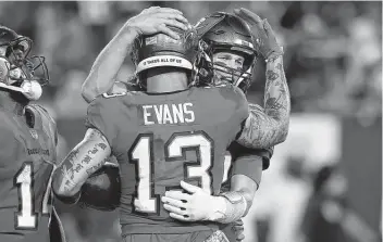  ?? Mark LoMoglio / Associated Press ?? Tampa Bay’s Mike Evans hugs quarterbac­k Tom Brady after Evans, a Texas A&M product, scored his franchise-record 72nd career touchdown for the Buccaneers to break Mike Alstott’s record.