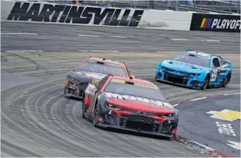  ?? AP PHOTO BY CHUCK BURTON ?? Ross Chastain races ahead of Kevin Harvick and Daniel Suarez (99) out of the fourth turn during a NASCAR Cup Series playoff race last October at Virginia’s Martinsvil­le Speedway.