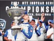  ?? Alex Gallardo / Associated Press ?? NTT IndyCar Series winner Alex Palou, center, celebrates with the trophy after taking fourth place in an IndyCar auto race at the Grand Prix of Long Beach on Sunday in Long Beach, Calif.