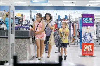  ?? LUIS SÁNCHEZ SATURNO/THE NEW MEXICAN ?? Mary Lujan Ney of Santa Fe, center, walks out of Ross at the DeVargas Center with her daughters Adeline Ney, 12, right, and Sienna Ney, 7, on Tuesday. The state’s annual tax-free holiday will run Friday through Sunday, but Lujan Ney said she didn’t...