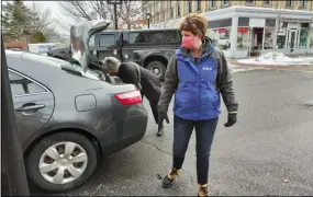  ?? MELISSA SCHUMAN - MEDIANEWS GROUP ?? Ballston Spa National Bank Volunteers put food into a car during their drive-thru food pantry in Cohoes.