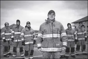  ?? CP Photo ?? Firefighte­r Mark Stephenson, centre, with fellow firefighte­rs raising money at a charity event, filmed his house burning in the Abasand neighbourh­ood last year during the wildfires in Fort Mcmurray, Alta.