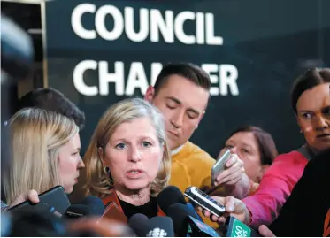  ?? CP PHOTO ?? Mary Moran, centre, CEO of the Calgary 2026 Bid Corporatio­n, speaks to reporters after Calgary city council voted on motions to kill the 2026 Winter Olympic bid and cancel a Nov. 13 plebiscite on whether the bid should proceed.