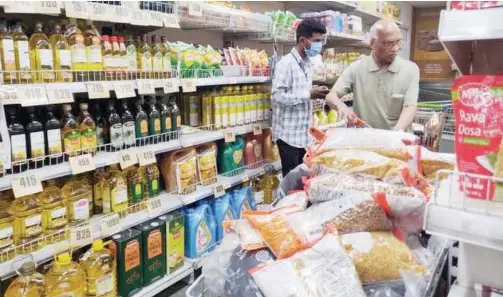  ??  ?? People buy grocery items at a department­al store in Gurugram, India.