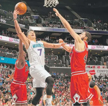  ?? | KENT SMITH/GETTY IMAGES ?? The Hornets’ Jeremy Lin glides between Bulls defenders and shoots over Nikola Mirotic on Tuesday.