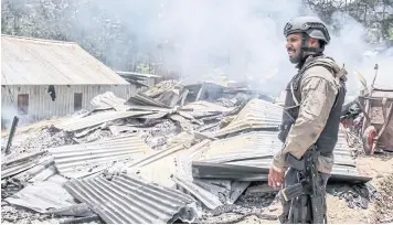  ?? AFP ?? A policeman secures an area where armed group burnt houses in Ilaga, Puncak district, Papua province last year.