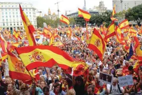  ??  ?? People wave Spanish flags during a demonstrat­ion for the unity of Spain in Barcelona.