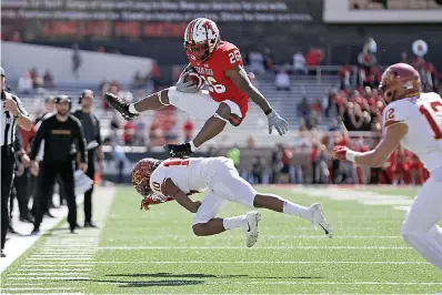  ?? Brad Tollefson/Lubbock Avalanche-Journal via AP ?? ■ Texas Tech's Ta'Zhawn Henry (26) hurdles over Iowa State's Tayvonn Kyle (10) during the second half of an NCAA college football game Saturday in Lubbock, Texas.