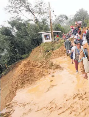  ??  ?? Residents of Itogon make their way to safety after mudslides buried dozens in the