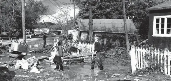  ?? TORONTO STAR ARCHIVES PHOTOS ?? Two boys carry a cot from a house near Etobicoke Creek in the aftermath of Hurricane Hazel. It claimed the lives of 81 people and remains one of the GTA’s worst natural disasters.