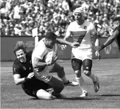  ??  ?? Tim Mikkelson (left) of New Zealand tackles Sacha Valleau of France during their Championsh­ips quarter finals game at the Rugby Sevens World Cup in the AT&T Park at San Francisco, California. — AFP photo