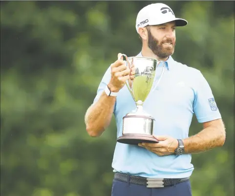  ?? Maddie Meyer / Getty Images ?? Dustin Johnson of the United States poses with the trophy after winning the Travelers Championsh­ip at TPC River Highlands on Sunday in Cromwell.