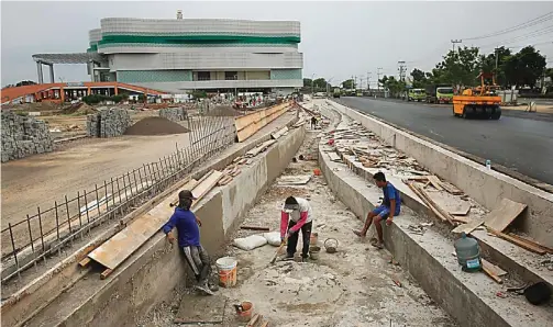  ?? DIMAS MAULANA/JAWA POS ?? BISA DIPERPANJA­NG 50 HARI: Pekerja masih mengerjaka­n areal parkir dan taman di Mal Pelayanan Publik (MPP) kemarin. Pembanguna­n proyek tersebut ditargetka­n selesai akhir tahun.