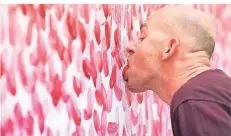  ?? FOTO: DPA ?? Künstler Benjamin Houlihan beweist Zungenfert­igkeit: Er „malt“sein Bild im Kunstmuseu­m Wolfsburg mit der Zunge.