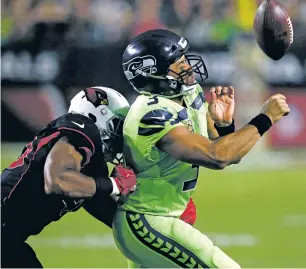  ?? ROSS D. FRANKLIN/THE ASSOCIATED PRESS ?? Cardinals linebacker Hasson Reddick knocks the ball out of Seahawks quarterbac­k Russell Wilson’s hands Thursday in Glendale, Ariz. Seattle won, 22-16.