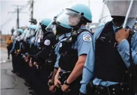  ?? ASHLEE REZIN GARCIA/SUN-TIMES FILES ?? Chicago police officers stand near East 71st Street and South Chappel Avenue in South Shore on June 1, 2020, after a weekend of protests, riots and looting throughout the city.