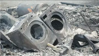  ?? JONATHAN HAYWARD/THE CANADIAN PRESS ?? The remains of a washer, dryer, water heater and a bathtub are about all that is recognizab­le in Boston Flats after a wildfire hit the area earlier in the week.