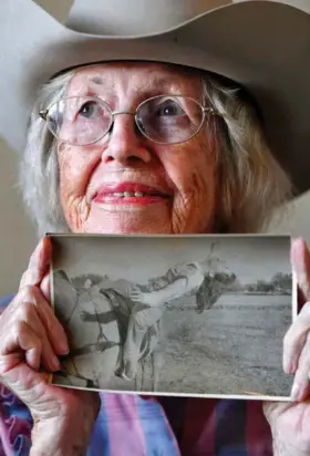  ?? Ronald W. Erdrich/The Abilene Reporter-News via AP ?? ■ Virginia Reger holds an undated photograph of her performing one of her trick riding stunts. Reger said she took a lot of falls over the years but never worried about them. “It just happens,” she said.