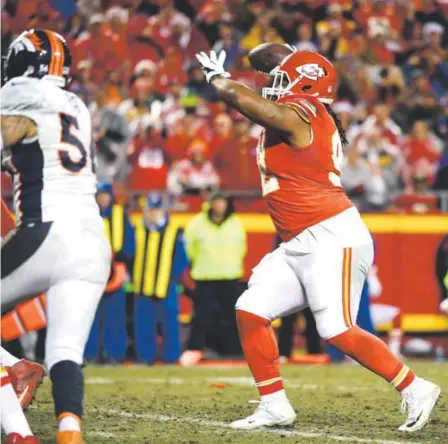  ??  ?? Kansas City nose tackle Dontari Poe, in on offense, throws a touchdown pass to tight end Demetrius Harris during the fourth quarter Sunday night for the final score of the game in the Chiefs’ 33-10 victory over the Broncos. Joe Amon, The Denver Post