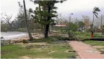  ?? PHOTO: REUTERS ?? Residents walk along the damaged foreshore at Airlie Beach.