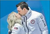  ?? Andreas Rentz Getty Images ?? BRONZE MEDALISTS Alexa and Chris Knierim celebrate with a kiss during awards ceremony.