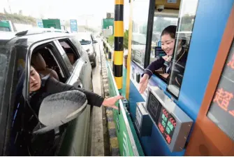  ??  ?? A driver uses Wechat to pay his highway toll fee at a toll booth in Guiyang, Guizhou Province, December 20, 2018