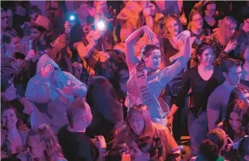  ?? RIAN WIDDIS/CHICAGO TRIBUNE ?? Caithleen Newell, center, of Troy, Michigan, wears an outfit referencin­g the chandelier in “The Phantom of the Opera” as she dances at Broadway Rave, a touring dance party celebratin­g musical theater and show tunes, at St. Andrew’s Hall in Detroit on Jan. 19.