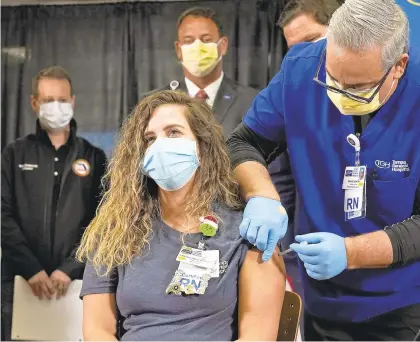  ?? CHRIS OMEARA/AP ?? A nurse gets a Pfizer COVID-19 vaccine shot during a news conference Monday at Tampa General Hospital in Tampa, Florida.