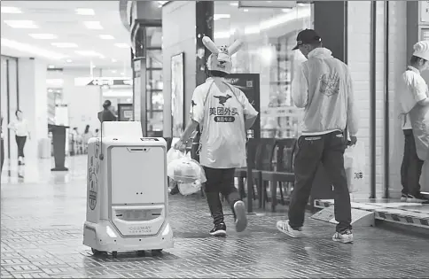  ?? PROVIDED TO CHINA DAILY ?? An autonomous delivery robot operates in Chaoyang Joy City in Chaoyang district of Beijing. By typing their phone number on a screen installed on the top of the robot, people working in the building can access food deliveries stored in the “belly” of the robot