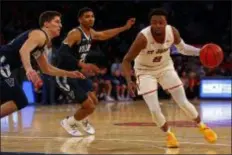  ?? ADAM HUNGER — THE ASSOCIATED PRESS ?? St. John’s guard Shamorie Ponds, right, drives to the basket past Villanova forward Jermaine Samuels, center, and guard Collin Gillespie during the second half of a 71-65 win by the Red Storm Sunday.