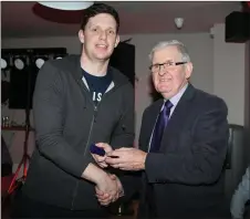  ??  ?? Joe Kearns presenting Junior Hurling Team member Tom O’ Reilly with his medal at the Kilbrin GAA Medals Presentati­on Event.