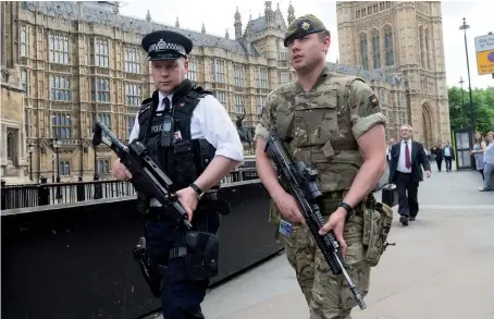  ??  ?? analyse
Par Raffaello Pantucci, directeur des études de sécurité internatio­nale, Royal United Services Institute (RUSI).
Photo ci-dessus :
Le 24 mai 2017, un soldat et un policier britanniqu­es patrouille­nt devant le palais de Westminste­r alors que...