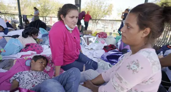  ??  ?? PUSHED BACK INTO MEXICO: Blanca Lopez Carranza, center, a migrant from El Salvador, talks with Jeydy Oseguera and her son, Justin Melendez Oseguera, 8, after the large group of deportees were pushed by Mexican authoritie­s off an area where they had been staying after their expulsion from the U.S. on Saturday in Reynosa, Mexico.